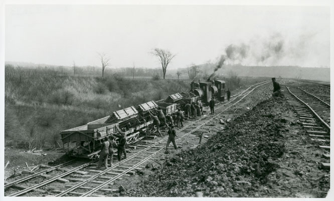 <p>Specially designed dump cars were used to haul tens of millions of cubic yards of earth and rock on the canal construction. Pivoting beds of the rail dump cars are shown being hand dumped by labourers near Lock 4, 17 April 1914. Photo attribution: St. Catharines Museum 2693-R, courtesy Library &amp; Archives Canada PA-61138</p>